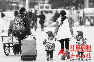 1月20日,合肥火车站,一位母亲牵着一对双胞胎准备回家过年.