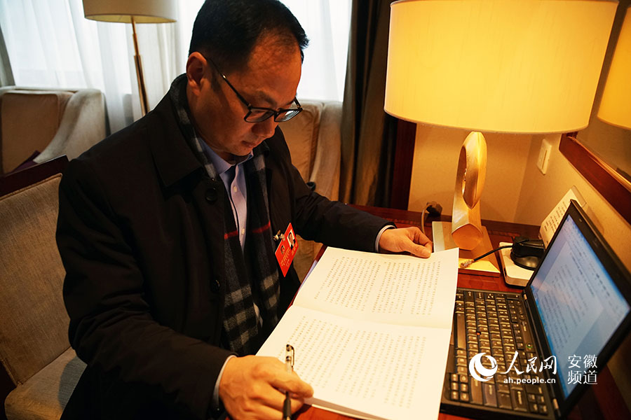完成報到程序后，安徽省政協委員汪姜峰第一時間在房間翻閱會議材料。李希蒙攝