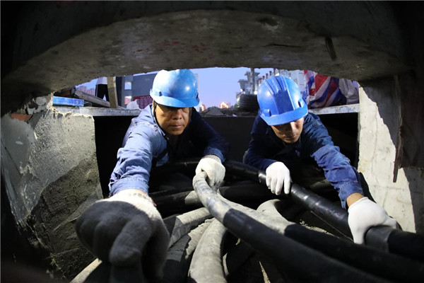 6月27日晚,在砀山中学新建配电室内,电力员工正在进行电缆安装作业.