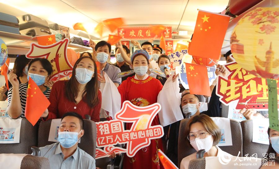 G266次列車上，工作人員與旅客合影留念。梁浩然 攝