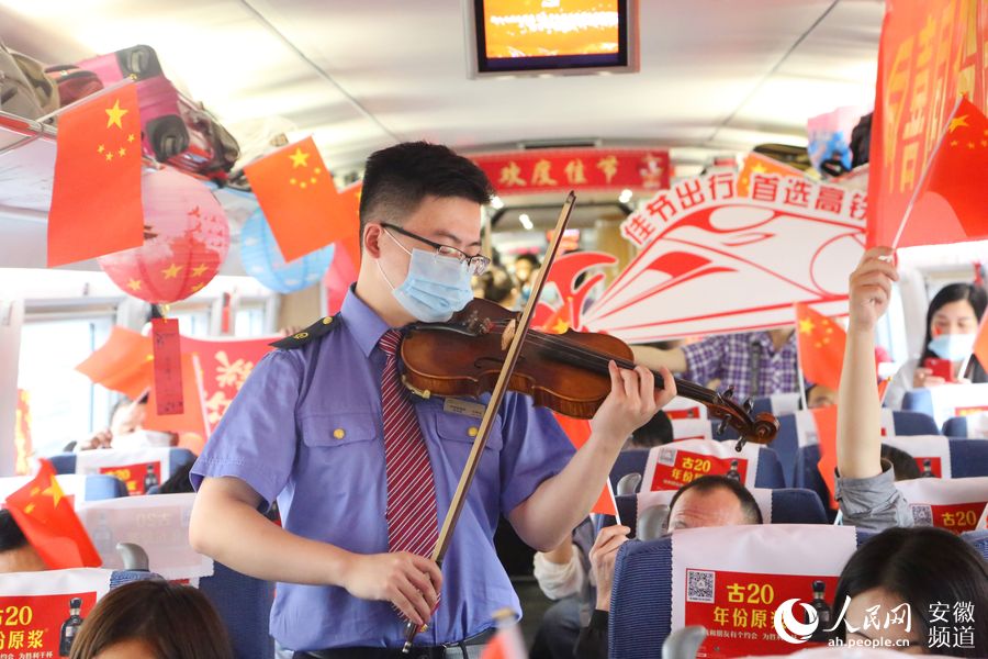 G649次列車上，工作人員為旅客表演小提琴獨奏《明月千裡寄相思》。梁浩然 攝