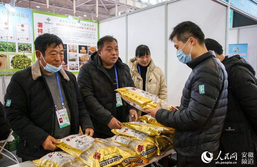 張愛章、張愛好兄弟倆正在向顧客推介自家的紅薯粉絲。王銳攝