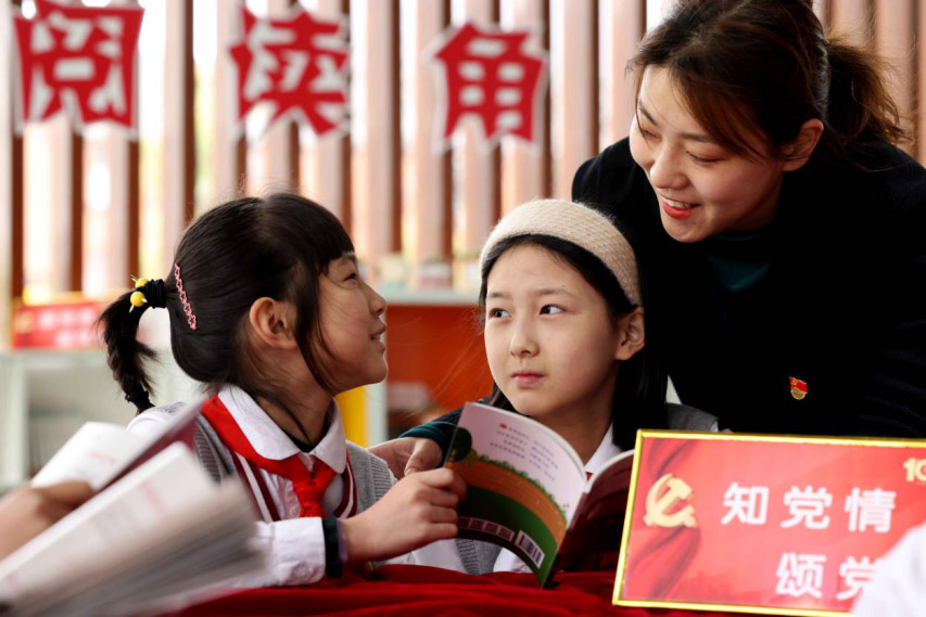 2021年3月31日，在合肥市瑤海區大通路小學的“黨史閱讀角”，孩子們在老師的輔導下學習閱讀青少年黨史讀物。解琛攝