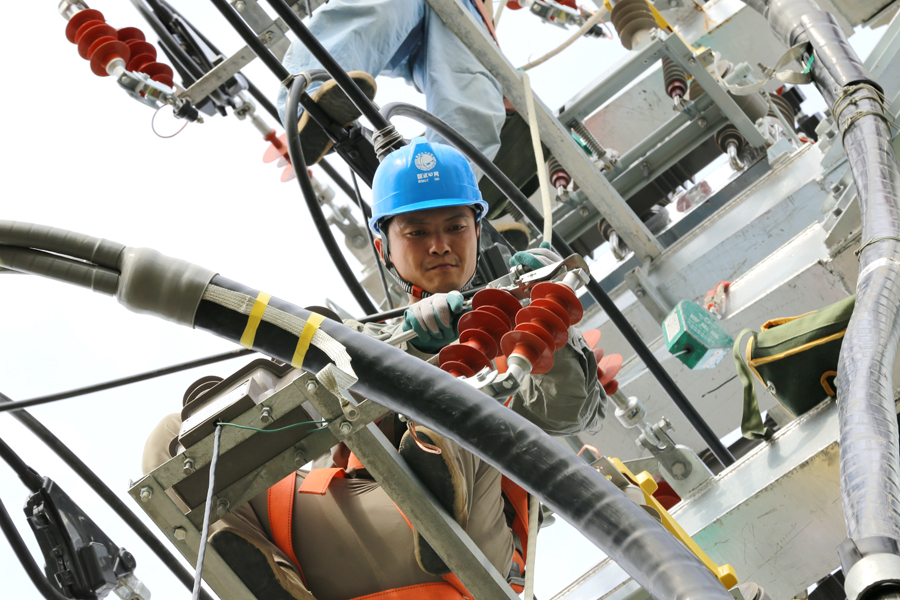 6月24日，亳州市利辛县供电公司员工正冒高温在钢管塔上安装10千伏线路避雷器。刘�瓷�