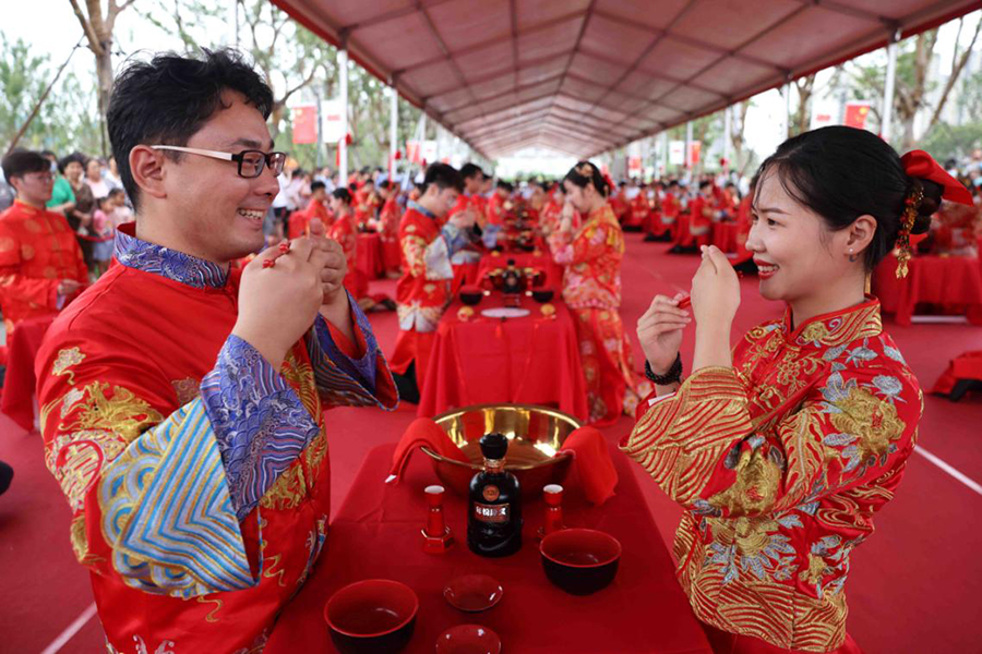 百位新人身着华美中式礼服参加传统婚典礼仪。谢琛摄