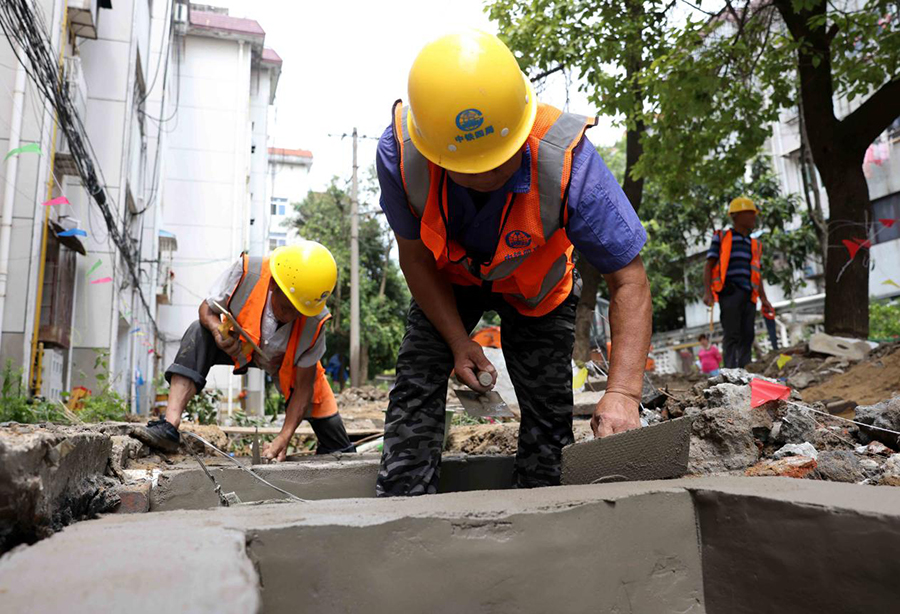 2021年7月13日，工人在合肥市瑤海區汪塘新村老舊小區整治現場施工。解琛攝