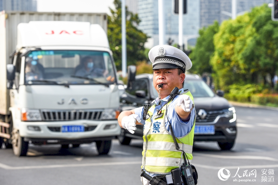 合肥交警公巡一大隊唐超警官正在早高峰擁堵路段疏導交通。人民網 李希蒙攝