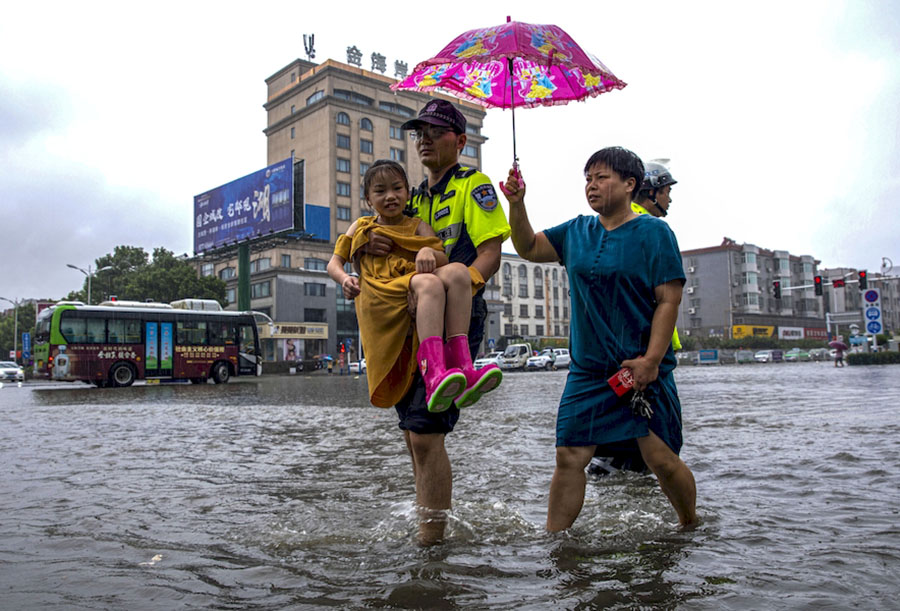 交警抱起孩子蹚過積水。左學長攝