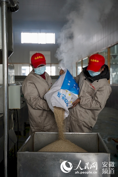 将精选出的芝麻倒进设备,准备漂洗。人民网 王晓飞摄