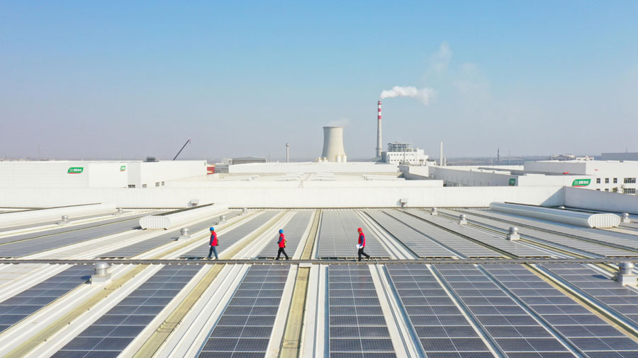2021年12月31日，在安徽省明光市三棵树涂料有限公司屋顶光伏发电站，电力工人协助企业做好冬季光伏发电站安全运维。