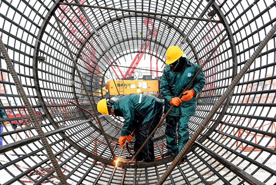 在G3銅陵長江公鐵大橋3號主墩施工現場，施工人員頂風冒雪安裝鑽孔樁鋼筋籠。過仕寧攝