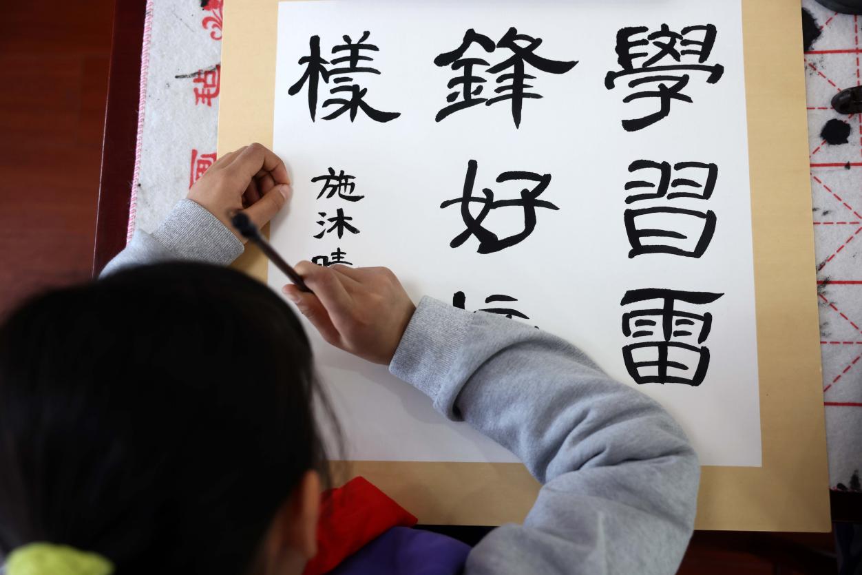 2022年3月4日，在合肥市少兒藝術學校，孩子在創作“雷鋒”題材書法作品。解琛攝