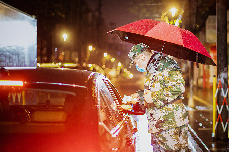 馬鞍山花山區防疫志願者夜晚冒雨對進入小區人員進行體溫檢測。王文生攝