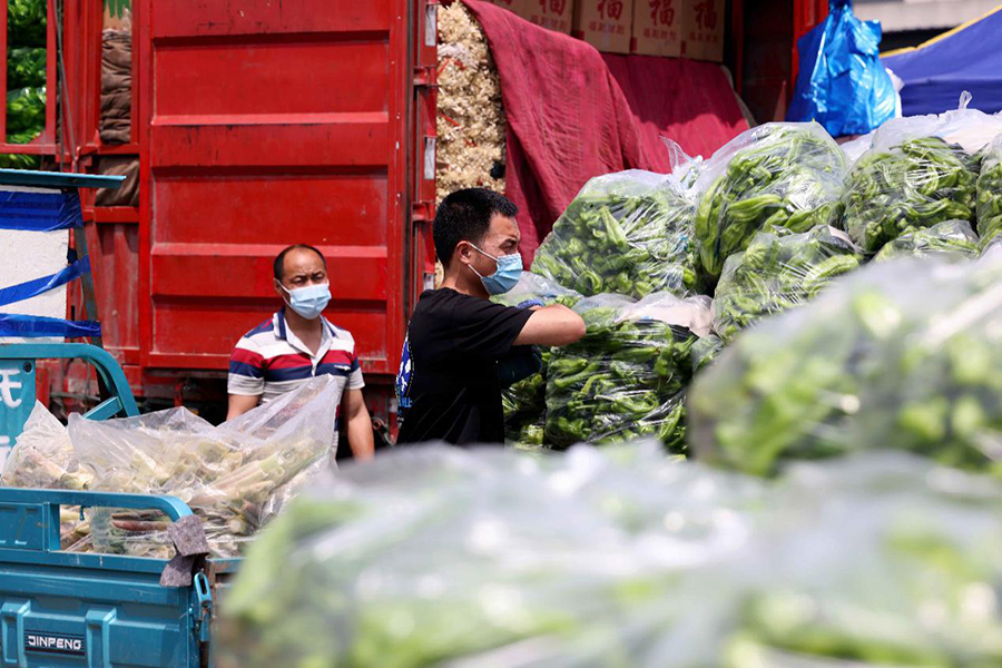 在安徽省合肥市周谷堆大興農產品物流園蔬菜交易中心，工人在搬運蔬菜。解琛攝