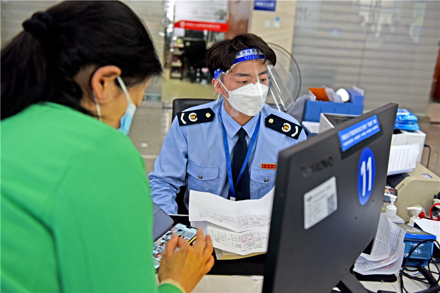 2022年4月25日，安徽省淮南市政務服務大廳稅務窗口，稅務工作人員為企業辦理涉稅業務，助力企業復工復產。陳彬攝