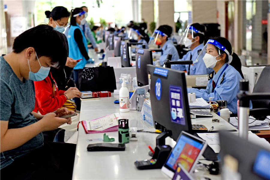 2022年4月25日，安徽省淮南市政務服務大廳稅務窗口，稅務工作人員為企業辦理涉稅業務，助力企業復工復產。陳彬攝