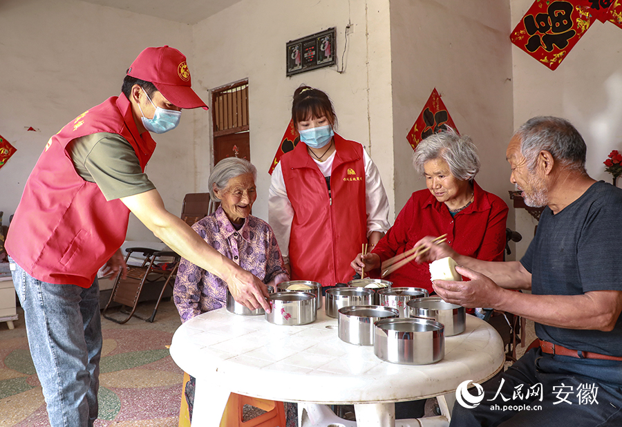 陳紅旗（左）和同事將打包好的飯菜送到一些失能、獨居、高齡的老年人家裡。