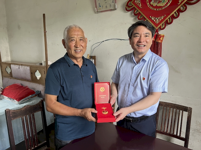 为退休老党员颁发“光荣在党50年”纪念章。桐城农商银行供图