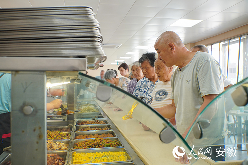 恆通社區老年食堂內，老人們正在排隊打菜。人民網 陳若天攝