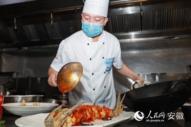 烹饪比赛现场，参赛厨师制作热菜。人民网 张俊摄