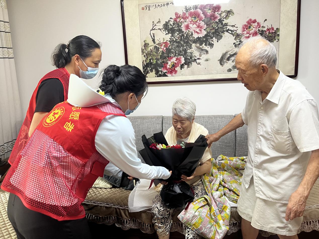 幸福坝志愿者向老红军夫妇献花。陈红燕摄