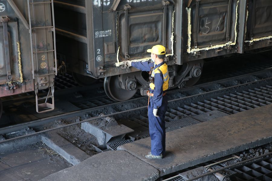 8月7日，宿州火车站调车组连结员邵石在闷热的电厂卸煤区认真确认一辆辆电煤车连接状态。
