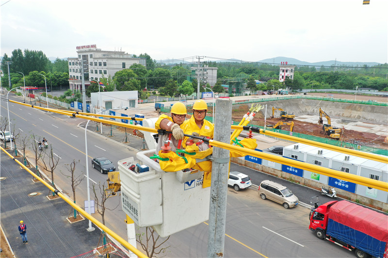 7月26日，马鞍山含山县供电公司员工在10千伏天鼓路129线凌家滩支线04号杆开展“带电移杆”作业。何林摄