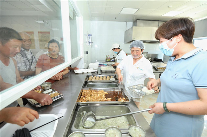 養老服務中心食堂的工作人員正在給老人打飯。劉煒鑫攝