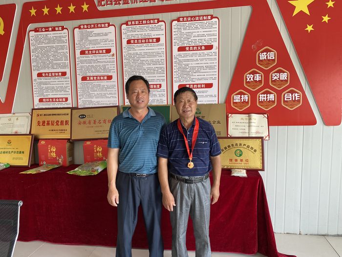 肥西县金桥红薯有限公司党支部书记黄学应为吴善平颁发纪念章。王淑宣供图