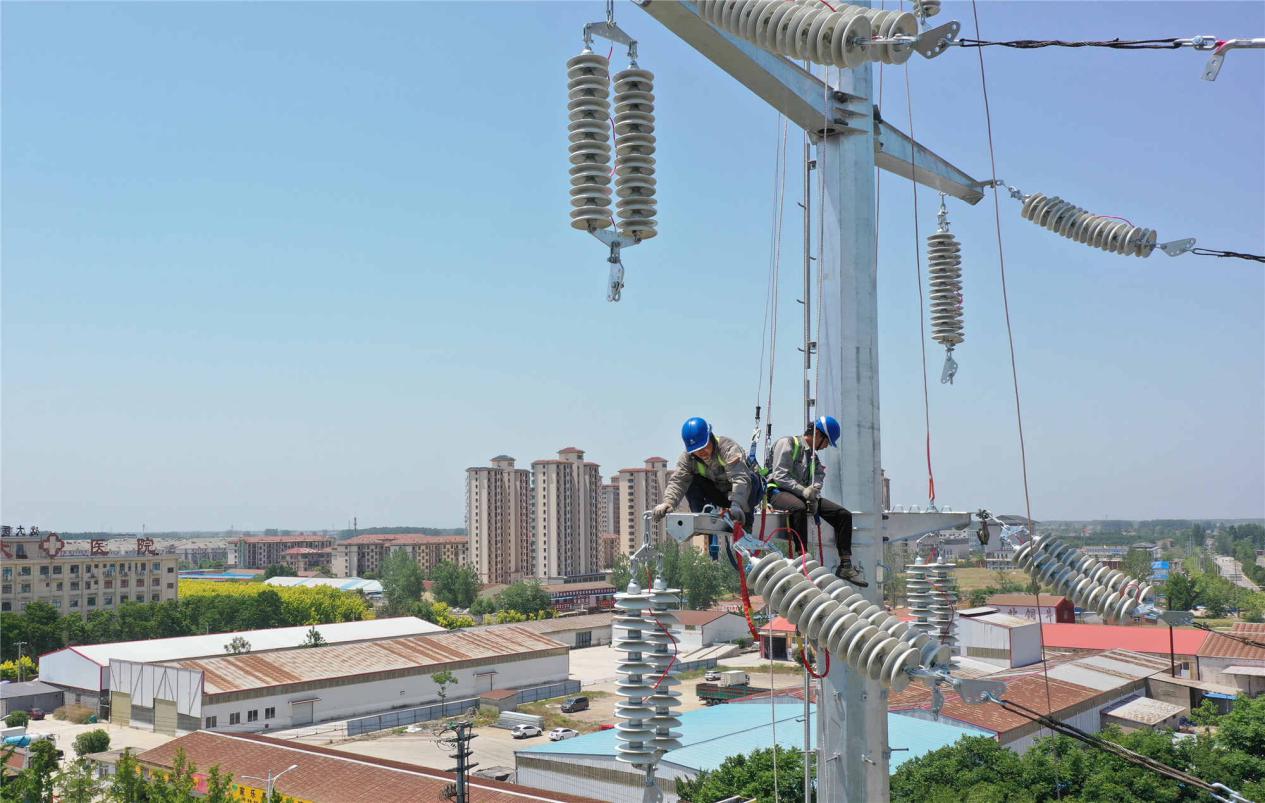 国网砀山县供电公司施工人员正在进行电力线路架设作业。张闯摄