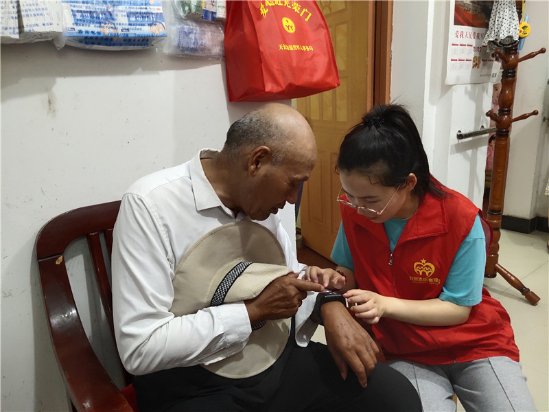 广陵街道“映山红”志愿服务队指导优抚抚对象使用健康监测腕表。刘世军摄