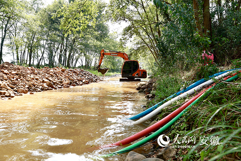 在宣州区周王镇，施工人员在河床上开挖渗水井。人民网 张俊摄