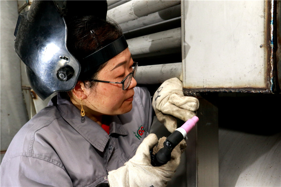 叶宜芳在检查10万大卡热能转换器内胆焊接质量。陈振伟、吴光磊供图