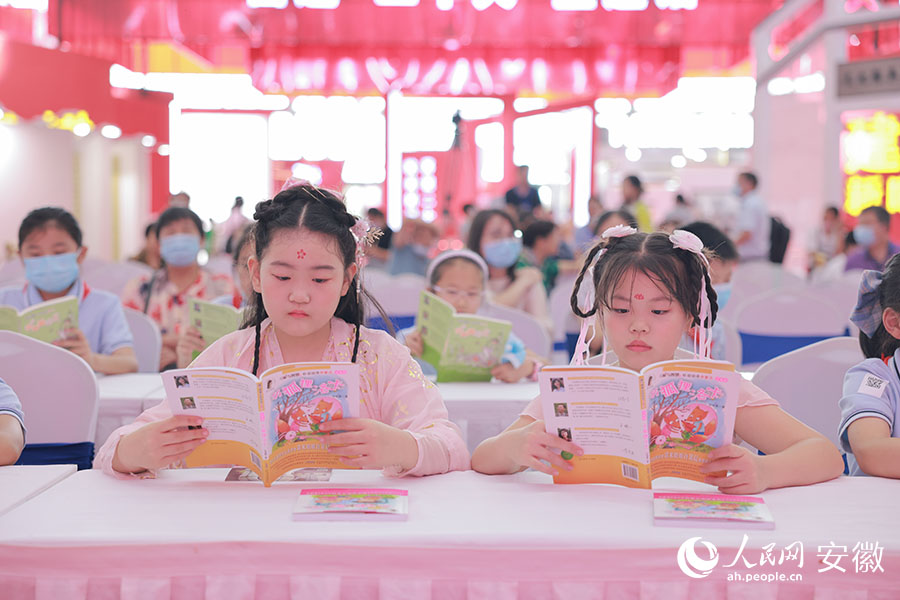 两位小朋友正在阅读“诺米姐姐”著作的书。人民网 王晓飞摄