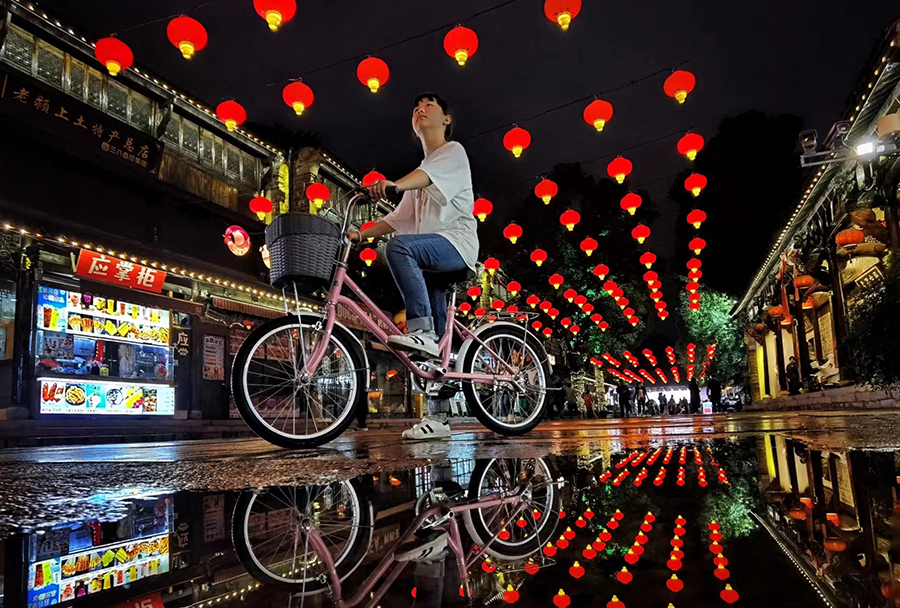 一位小女孩骑着自行车在管仲老街游玩。乐卫星摄