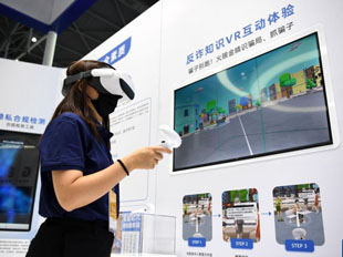 一家參展企業代表在演示反詐知識VR互動體驗項目