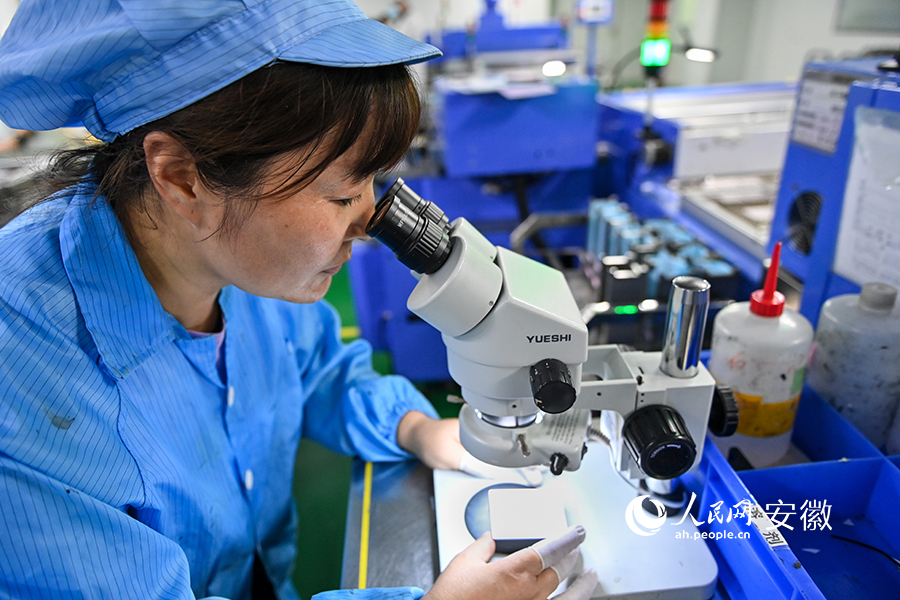 翔胜科技电阻生产车间里，工人对流水线上产品进行抽检。人民网记者 苗子健摄