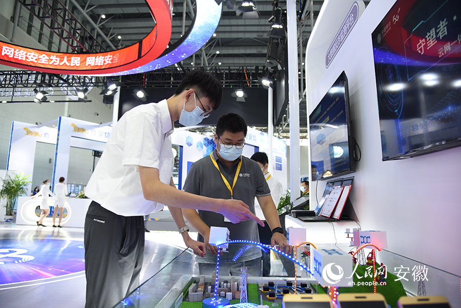 中国移动工作人员正在向参观者介绍网络安全产品。人民网 李希蒙摄