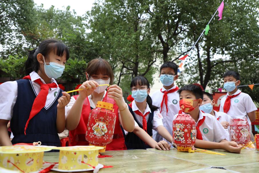 肥西县民生小学的小朋友在社区志愿者带领下拼装中秋元素花灯。颜安摄