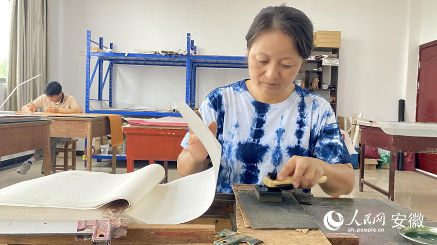 老师傅向记者展示操作木版水印。人民网 吕欢欢摄