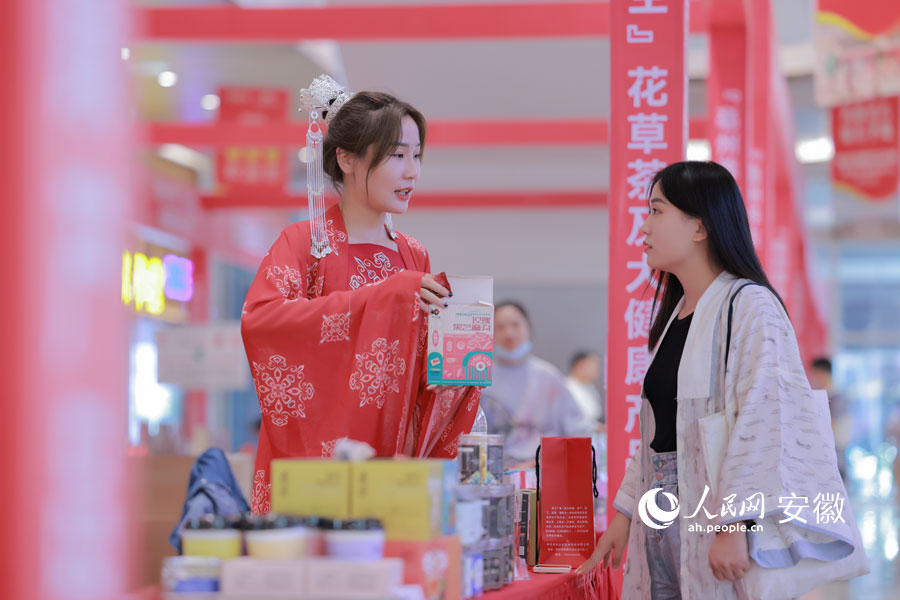 藥博會期間，一名身著古裝的女孩在向顧客介紹花草茶產品。人民網 王曉飛攝