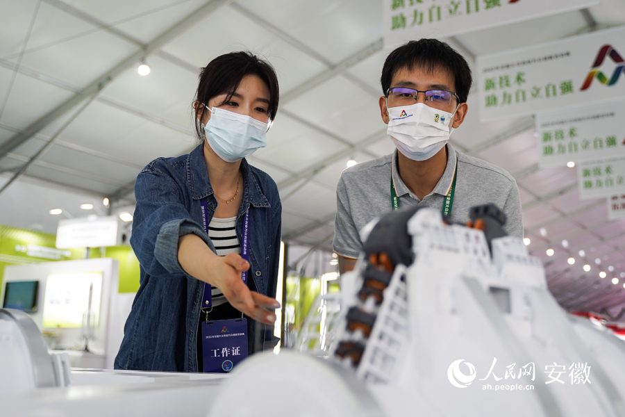 工作人员为市民介绍超导回旋质子治疗系统。人民网 王锐摄
