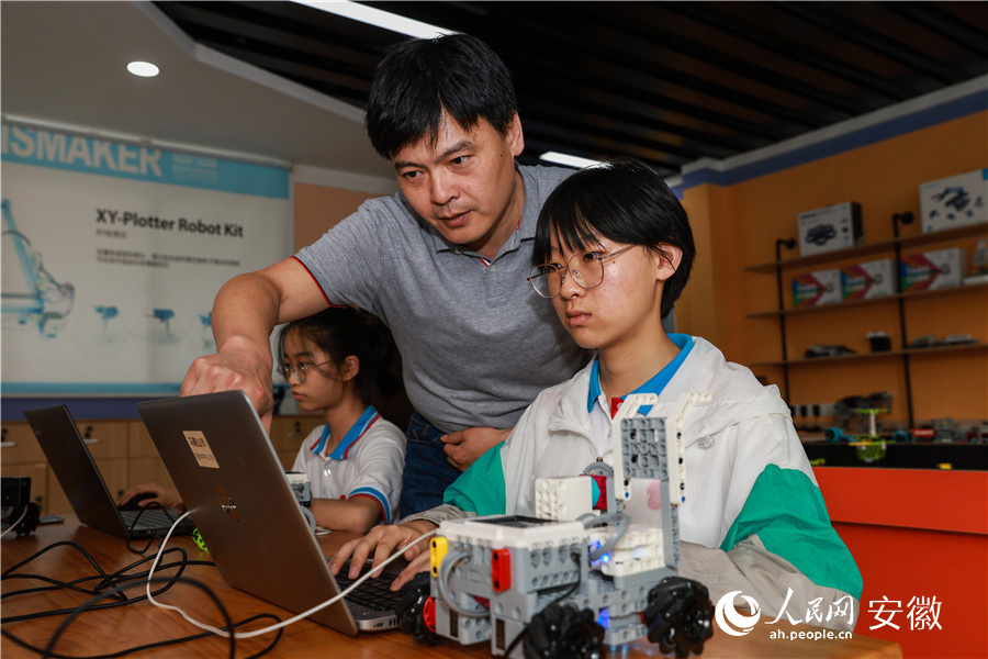 马鞍山市花园初级中学，机器人兴趣小组成员探讨机器人编程。人民网 张俊摄