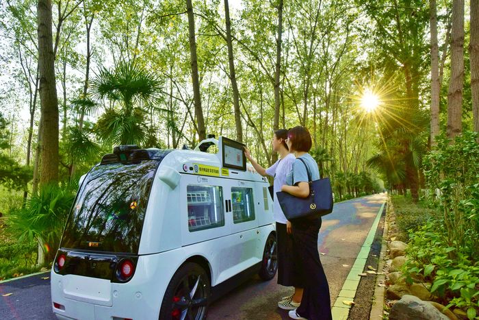 合肥濱湖國家森林公園內，游客在公園內通過無人駕駛的智行者售賣車購物。