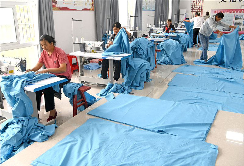 村民學習縫紉技術，加工被套出口海外。陳彬攝