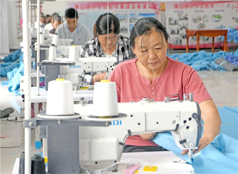 村民學習縫紉技術，加工被套出口海外。陳彬攝