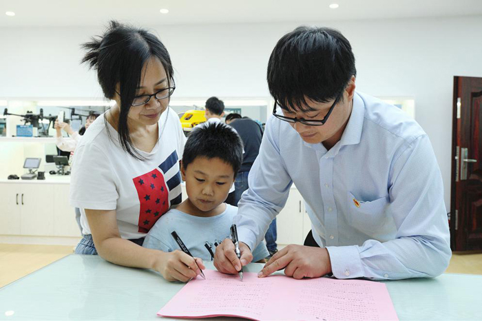 芜湖供电公司员工及其家属在家庭助廉承诺书上签字。韩俊供图