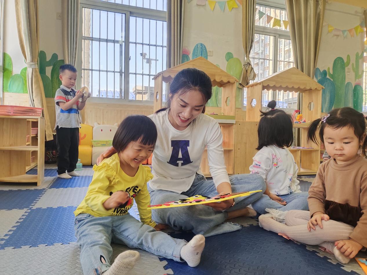 幼托班老師杜宏嬌正在教劉奕彤小朋友（左一）做手工。
