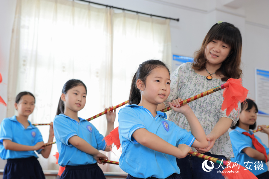 一位老师正在给学生指导莲湘舞的动作。人民网 王晓飞摄
