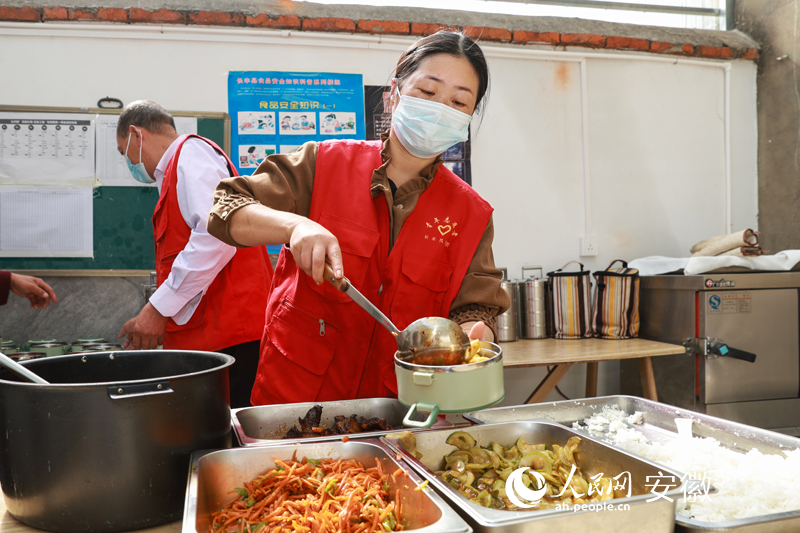 长丰县义井镇志愿者为老人打中饭，准备送餐。人民网 张俊摄